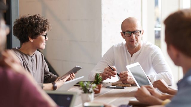 Photo of Man Sitting in Front of People